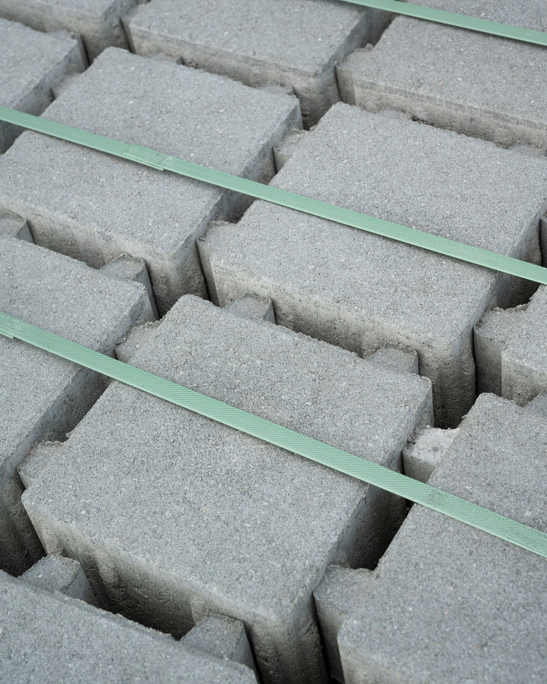 Grey blocks laid in rows with green seams between them
