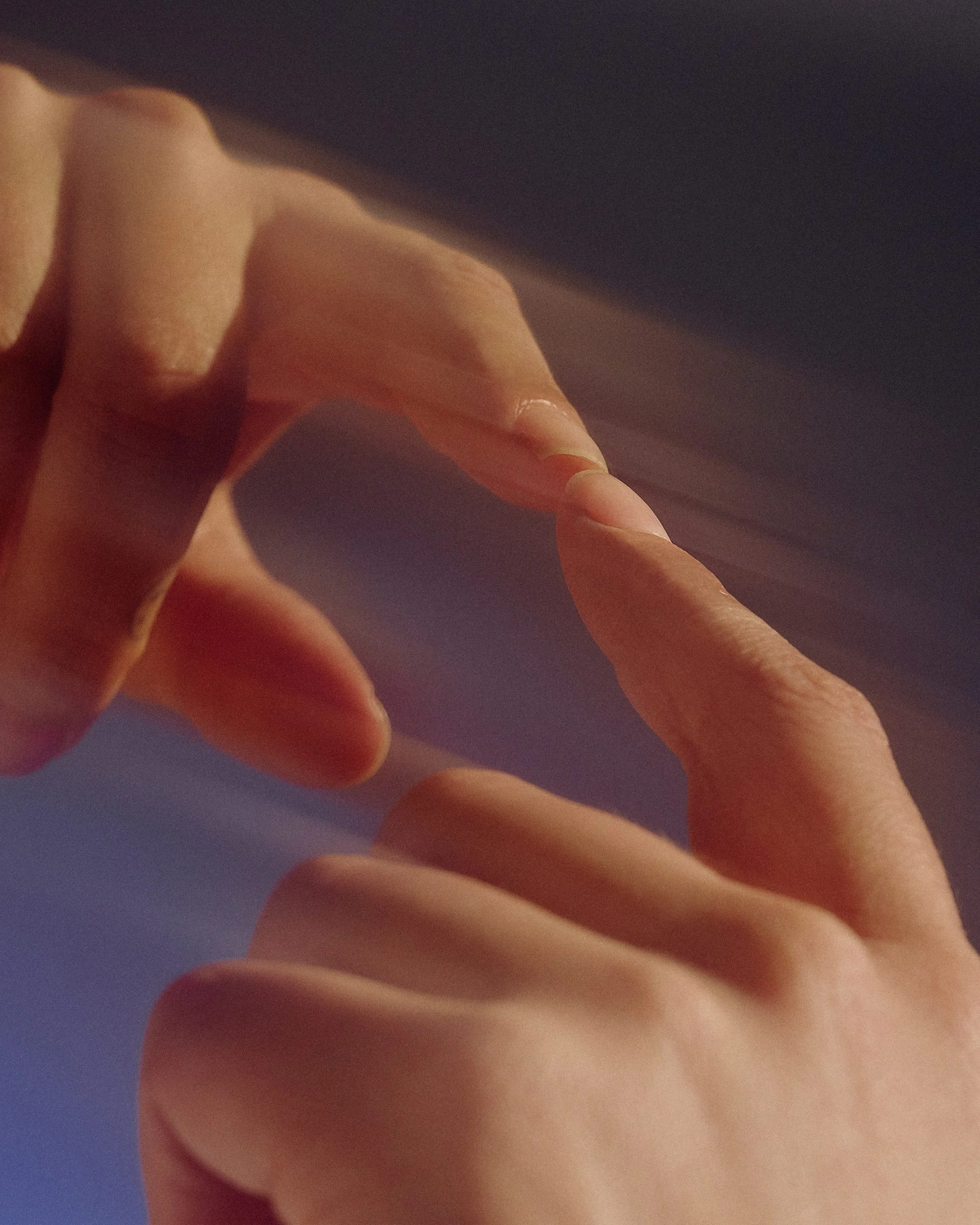 Close-up of hands, softly blurred, in warm light