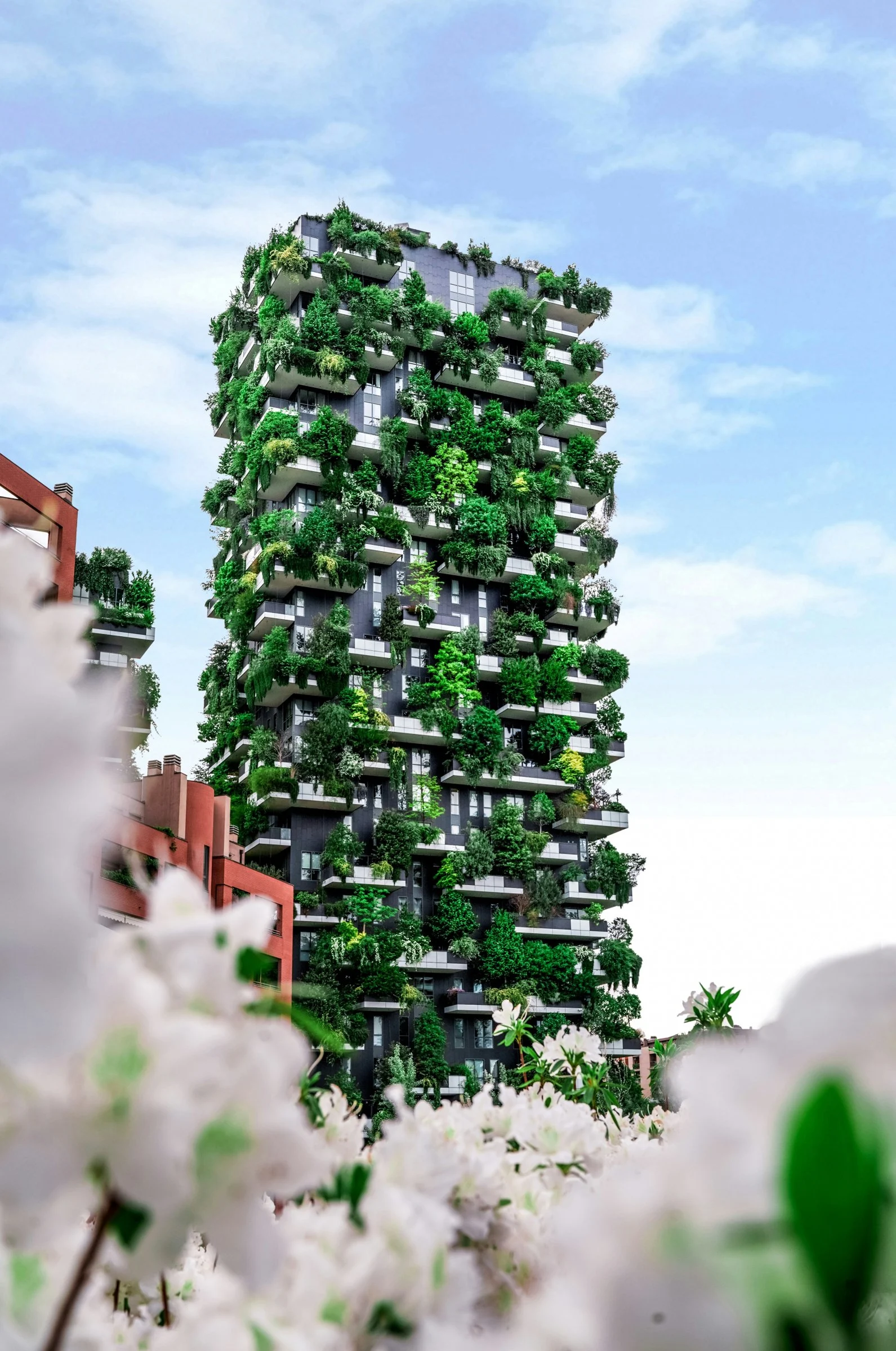 A tower block covered in trees and planting